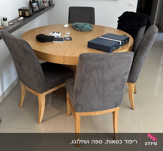 שולחן עגול עם כיסאות מרופדים בצבע אפור